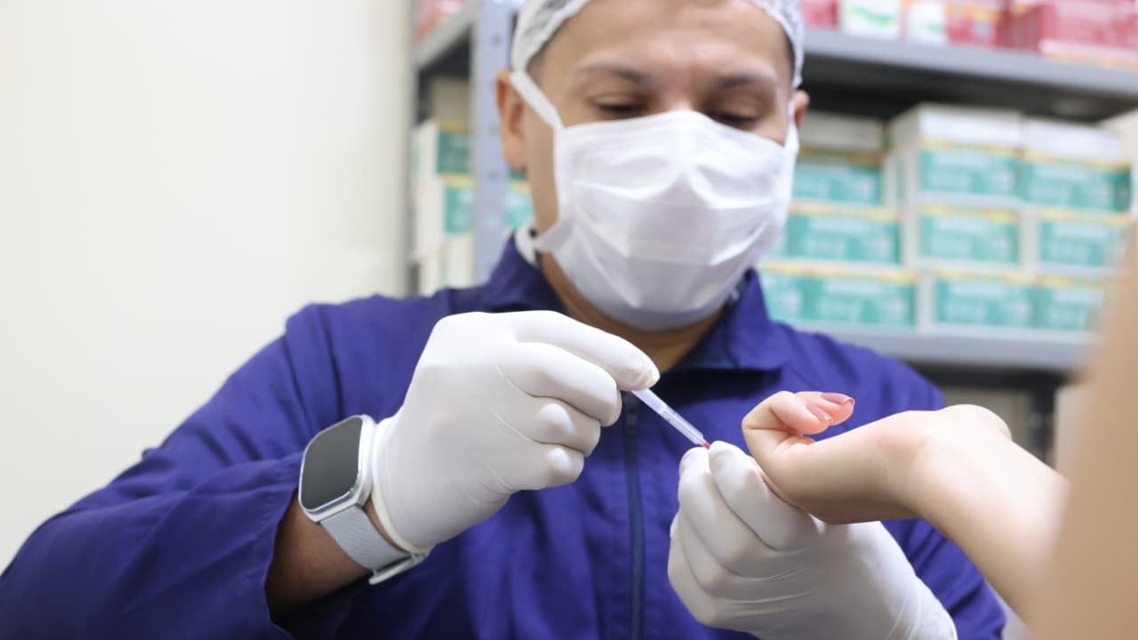 enfermeiro usando uma agulha para picar o dedo de uma pessoa para fazer o teste
